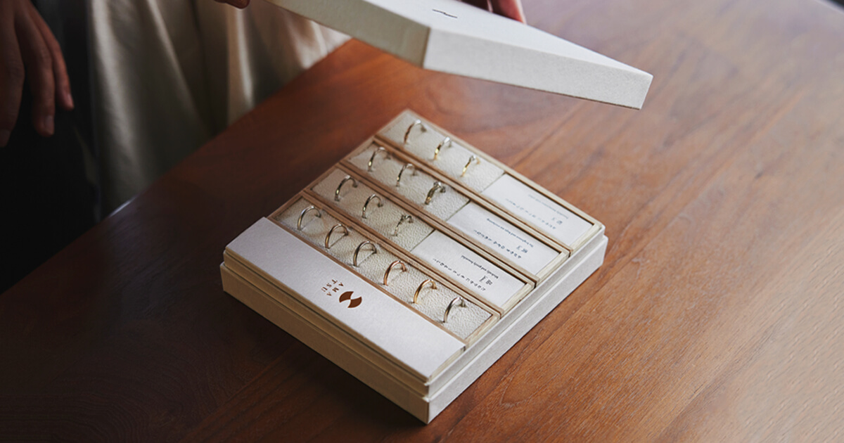 AMATSUのサンプルリング貸出しサービスで、ご自宅に届いた結婚指輪・婚約指輪のサンプルリング一式を確認している様子