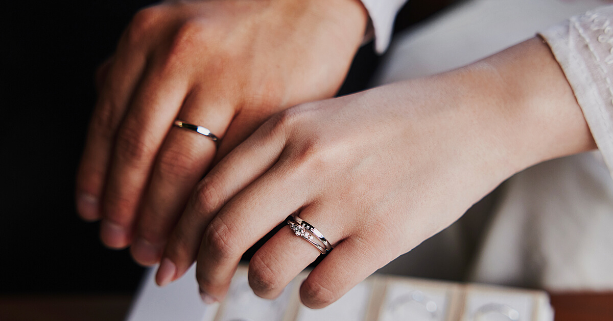 AMATSUの結婚指輪を身につけたおふたりと、婚約指輪を重ね着けした女性の手元